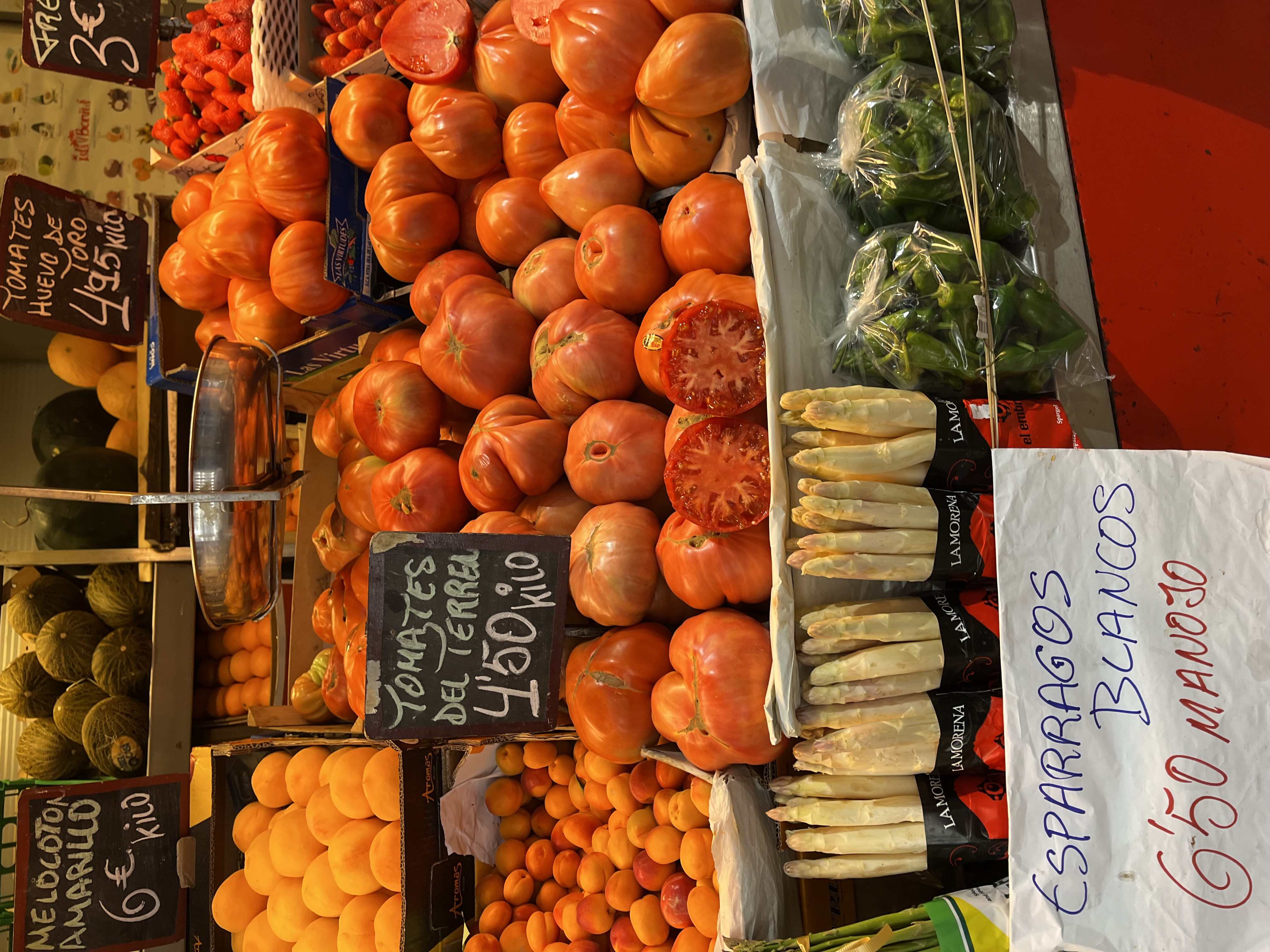 A market stall piled with tomatoes, asparagus and fresh produce, evoking the vegetable-led cooking associated with Murcia&rsquo;s huerta.